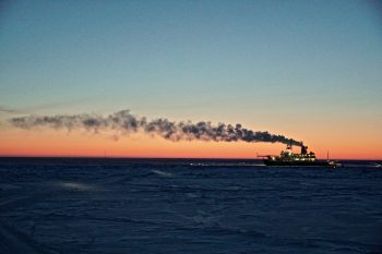 Figure 6a. The German icebreaker Polarstern drifts with the sea ice, where it has been lodged since September 2019 as part of the MOSAiC project. As the project heads into spring, a perpetual sunrise eclipses the horizon. ||Credit: J. Stroeve, NSIDC | High-resolution image
