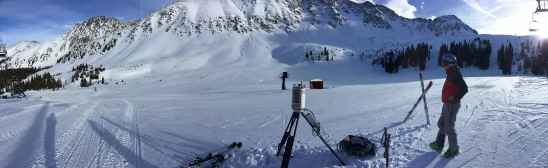 Photograph of a researcher scanning snow depth