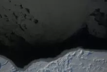 The bottom part of this image shows a thin layer of ice bordering snow-covered, thick and ridged sea ice in the East Beaufort Sea. The rest of the image shows a lead that is mostly covered by large plates of dark nilas. Leads are narrow, linear cracks in the ice that form when ice floes diverge or her as they move parallel to each other. Credit: NASA/Operation Ice Bridge. High-resolution image