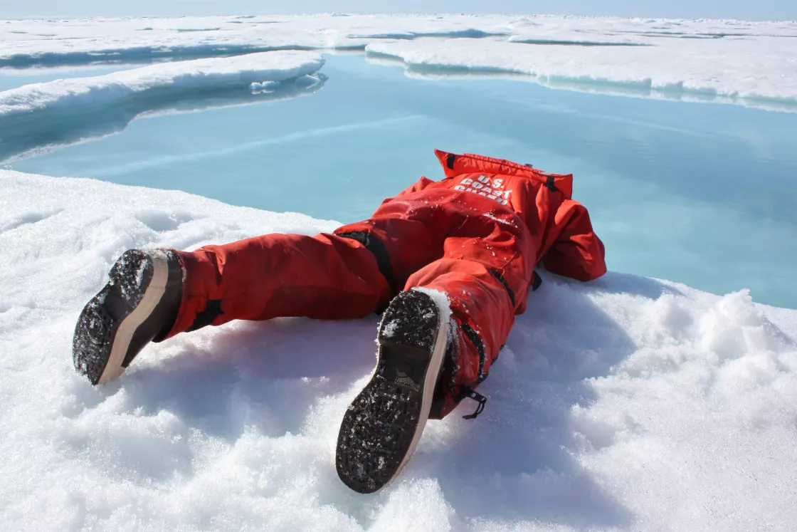 A researcher sips freshwater from a melt pond on sea ice in the Arctic ocean.