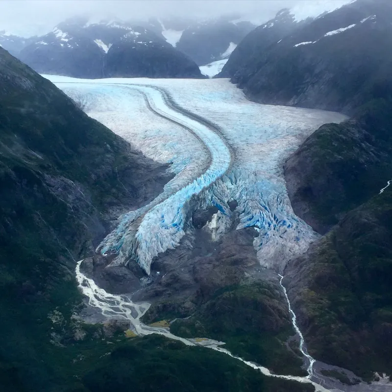Glaciers, or accumulations of ice and snow that slowly flow over land, are disappearing as the planet heats up because of climate change. In this image, melt from a glacier extending from the Juneau Icefield in Alaska forms braided streams as the glacier retreats. The Global Land Ice Measurements from Space initiative is working to document disappearing glaciers. 