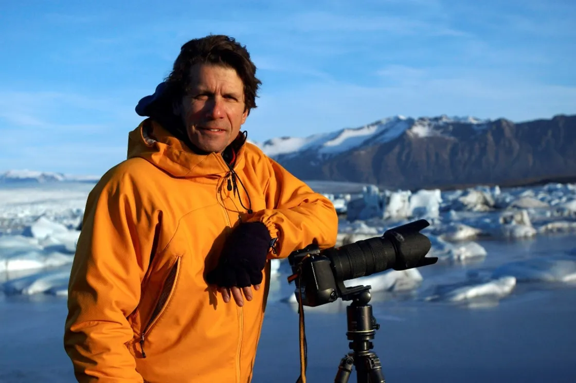 James Balog, founder and director of the Extreme Ice Survey and the Earth Vision Institute, leans on his camera while photographing ice in the field at Jökulsárlón, Iceland. 