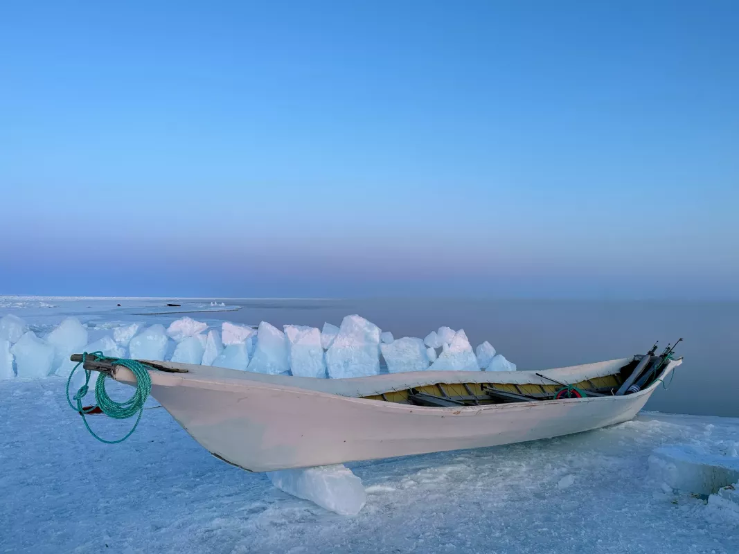 Seal skin boat rests at the ice edge near Tikiġaq