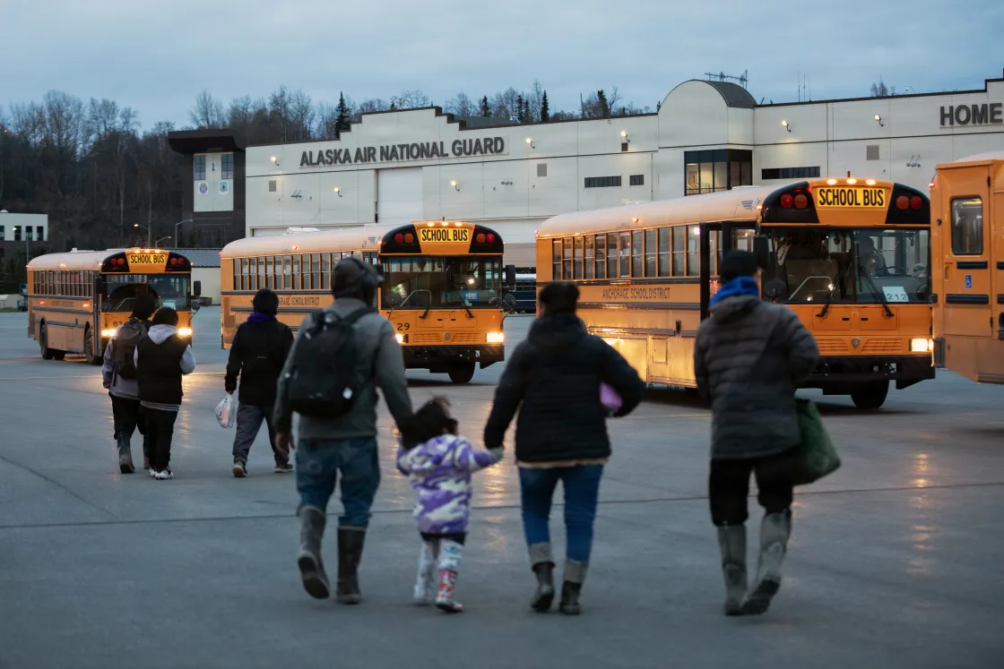 communities board buses after arriving at Joint Base Elmendorf-Richardson (JBER), Alaska