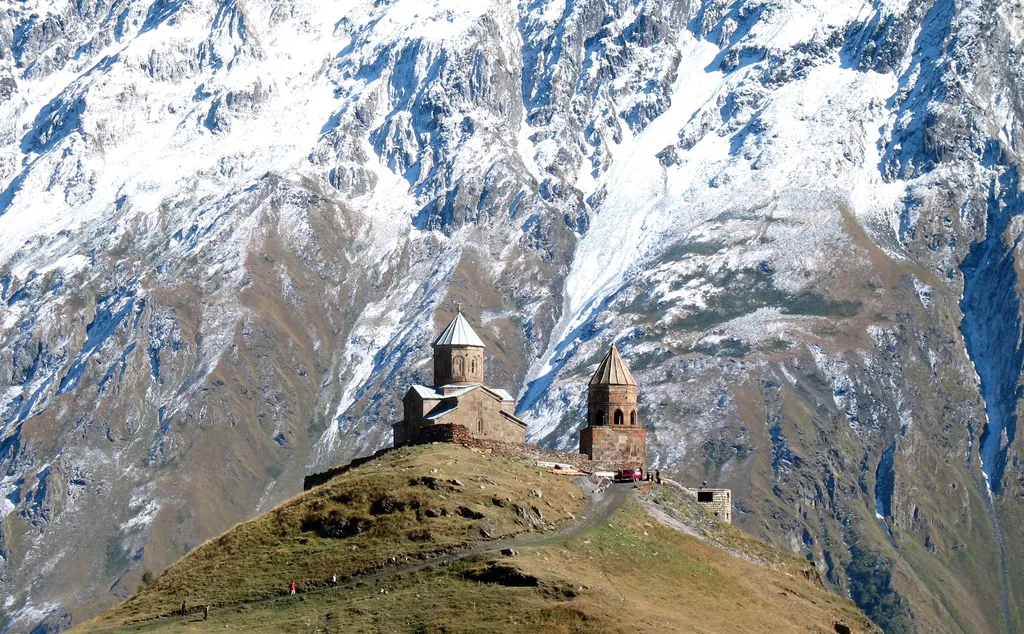 Photo of old church on summit with taller mountains in background