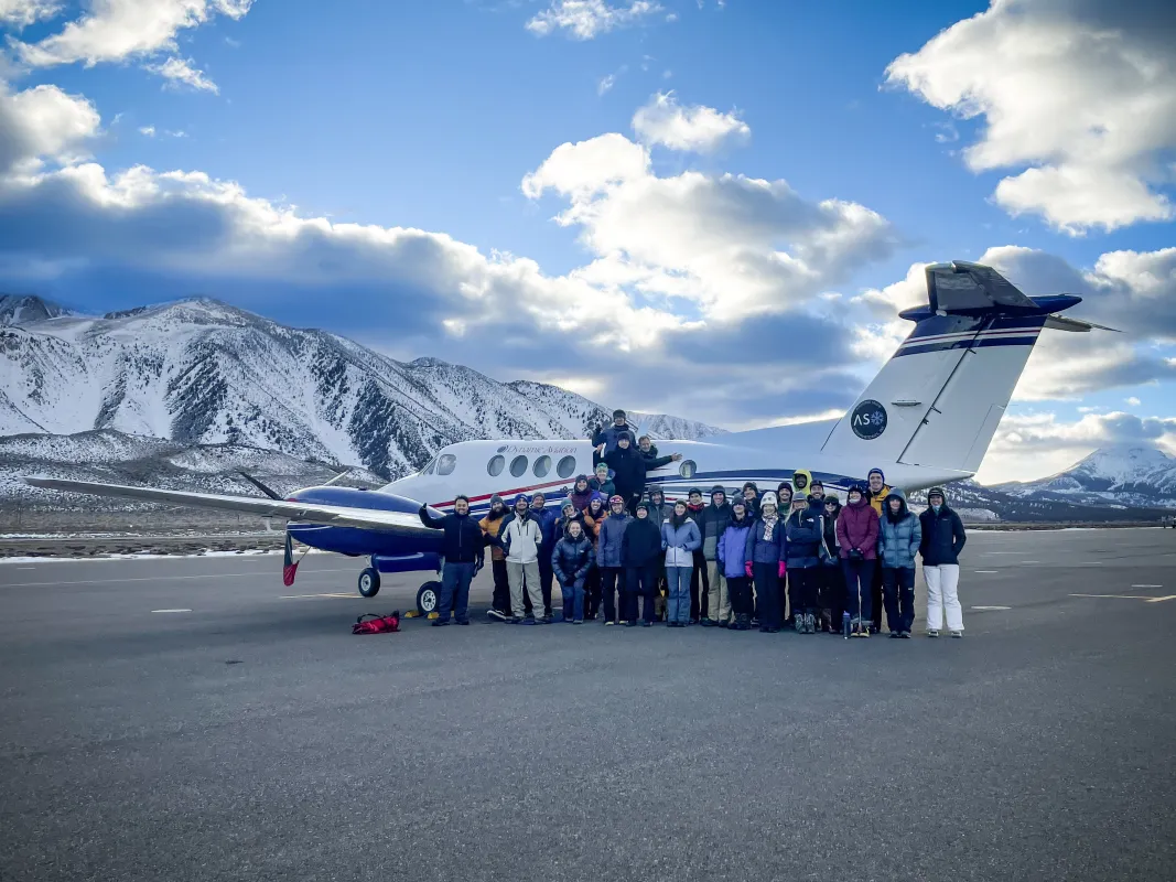 Researchers standing next to plane