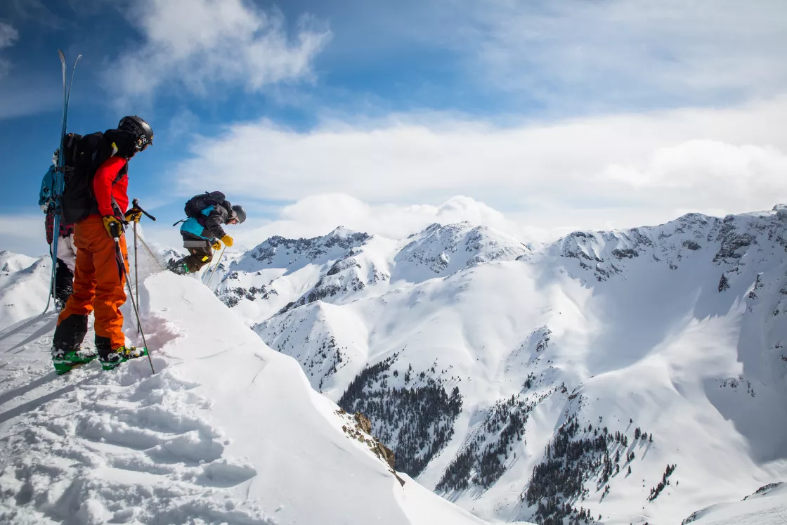 skiers drop in from a cliff in Silverton, Colorado