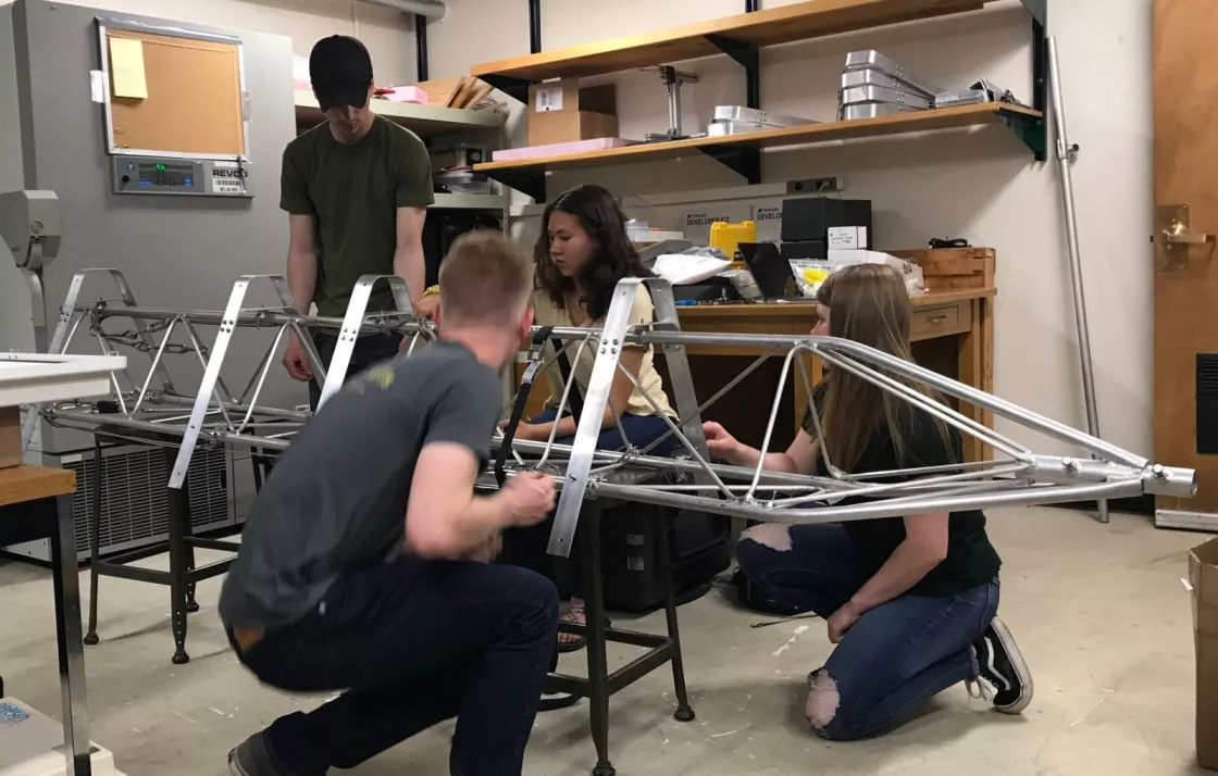 Team JANE assembling the AMIGOS tower with mounts to test for the solar panel attachment. From left to right: Jack Soltys, Ryan Weatherbee Skylar Edwards, and Emma Tomlinson. 