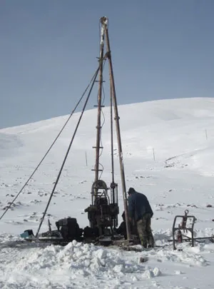 Photograph of researchers drilling a borehold through permafrost in China