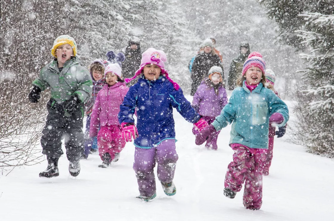 Children run on a trail during snowstorm