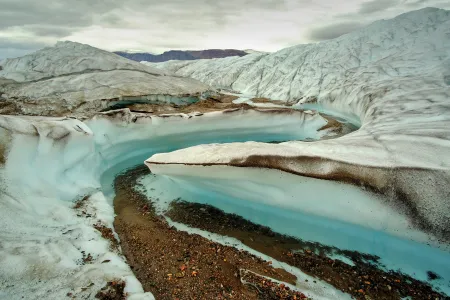 meltwater cuts into Greenland ice sheet, exposing dirt