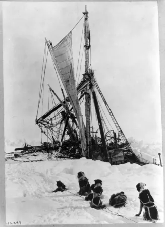Photograph of sinking ship and sled dogs in front