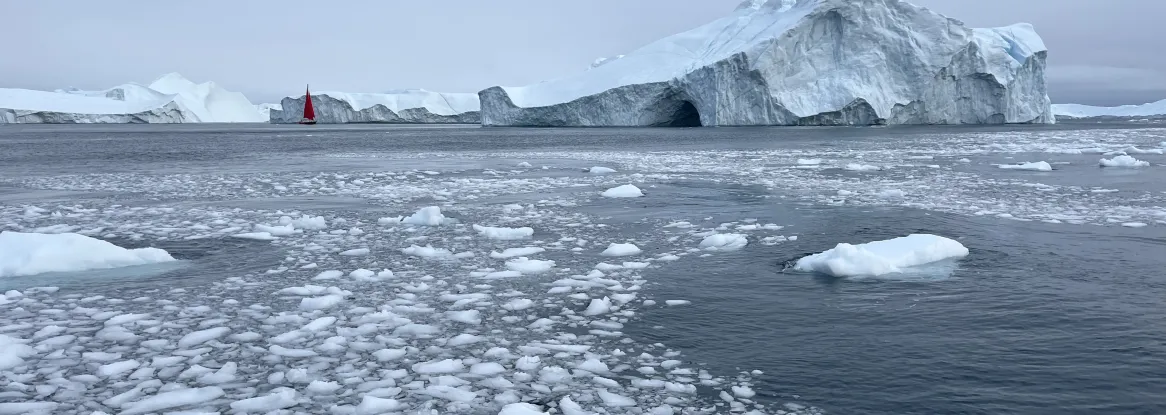 Arctic sea ice drifts in front of an iceberg