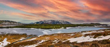 A colorful sunset lights up a tundra landscape